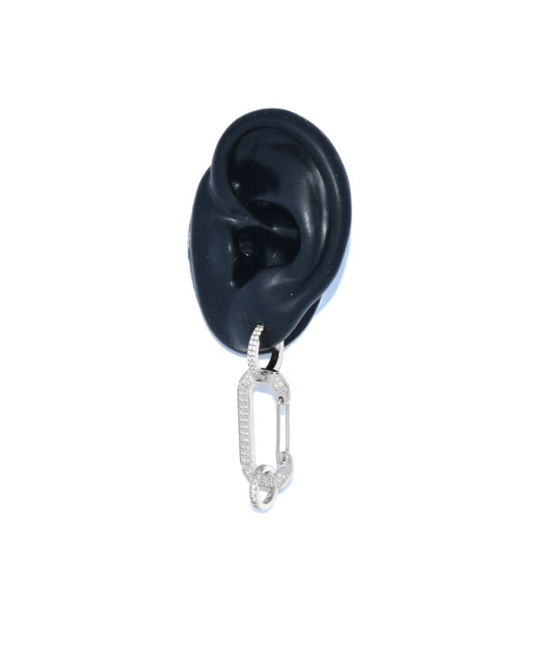 Een oor met daarin de zilveren Bonne oorbel met witte steentjes van Juli Dans Jewels