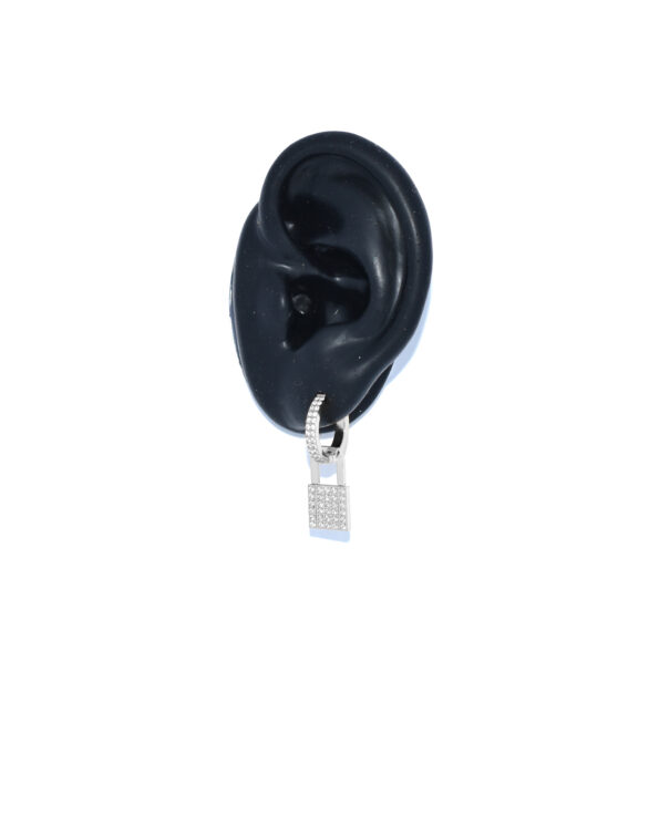 Zilveren slotje oorbel met witte steentjes in een oor van Juli Dans Jewels